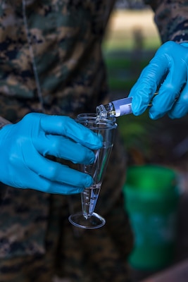 U.S. Navy Petty Officer 3rd Class Zacharia Stewart, a preventative medicine technician with Marine Rotational Force – Darwin 24.3, pours water into a specimen cup to be fitted onto a Coriolis Micro-Microbial Air Sampler at Royal Australian Air Force Base Darwin, NT, Australia, April 24, 2024. The Coriolis Micro-Microbial Air Sampler was used to test for the air born bacteria Burkholderia pseudomallei, which can cause Melioidosis, for a study done in partnership with the Menzies School of Public Health. MRF-D 24.3 is part of an annual six-month rotational deployment to enhance interoperability with the Australian Defence Force and Allies and partners and provide a forward-postured crisis response force in the Indo-Pacific. Stewart is a native of Oklahoma. (U.S. Marine Corps photo by Cpl. Earik Barton)