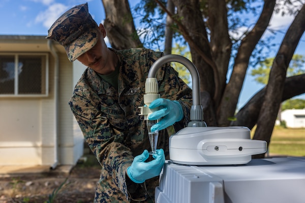 U.S. Navy Petty Officer 3rd Class Zacharia Stewart, a preventative medicine technician with Marine Rotational Force – Darwin 24.3, attaches a specimen cup to a Coriolis Micro-Microbial Air Sampler at Royal Australian Air Force Base Darwin, NT, Australia, April 24, 2024. The Coriolis Micro-Microbial Air Sampler was used to test for the air born bacteria Burkholderia pseudomallei, which can cause Melioidosis, for a study done in partnership with the Menzies School of Public Health. MRF-D 24.3 is part of an annual six-month rotational deployment to enhance interoperability with the Australian Defence Force and Allies and partners and provide a forward-postured crisis response force in the Indo-Pacific. Stewart is a native of Oklahoma. (U.S. Marine Corps photo by Cpl. Earik Barton)