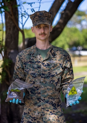 U.S. Navy Petty Officer 3rd Class Zacharia Stewart, a preventative medicine technician with Marine Rotational Force – Darwin 24.3, poses for a photo while holding water and soil samples gathered by a Coriolis Micro-Microbial Air Sampler at Royal Australian Air Force Base Darwin, NT, Australia, April 24, 2024. The Coriolis Micro-Microbial Air Sampler was used to test for the air born bacteria Burkholderia pseudomallei, which can cause Melioidosis, for a study done in partnership with the Menzies School of Public Health. MRF-D 24.3 is part of an annual six-month rotational deployment to enhance interoperability with the Australian Defence Force and Allies and partners and provide a forward-postured crisis response force in the Indo-Pacific. Stewart is a native of Oklahoma. (U.S. Marine Corps photo by Cpl. Earik Barton)