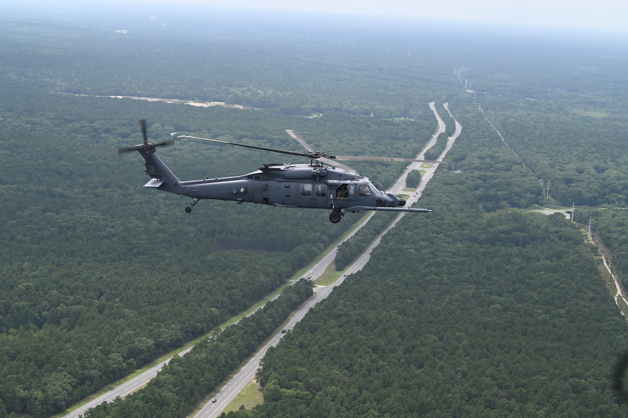A U.S. Air Force HH-60W Jolly Green II search and rescue helicopter assigned to the 106th Rescue Wing based at Francis S. Gabreski Air National Guard Base, Westhampton Beach, N.Y., flies over the north shore of Long Island, August 4, 2024. 106th aircrew demonstrated the upgraded functions of the aircraft over land and water during the wing’s historic first HH-60W flight. (U.S. Air National Guard photo by Senior Airman Sarah McKernan)