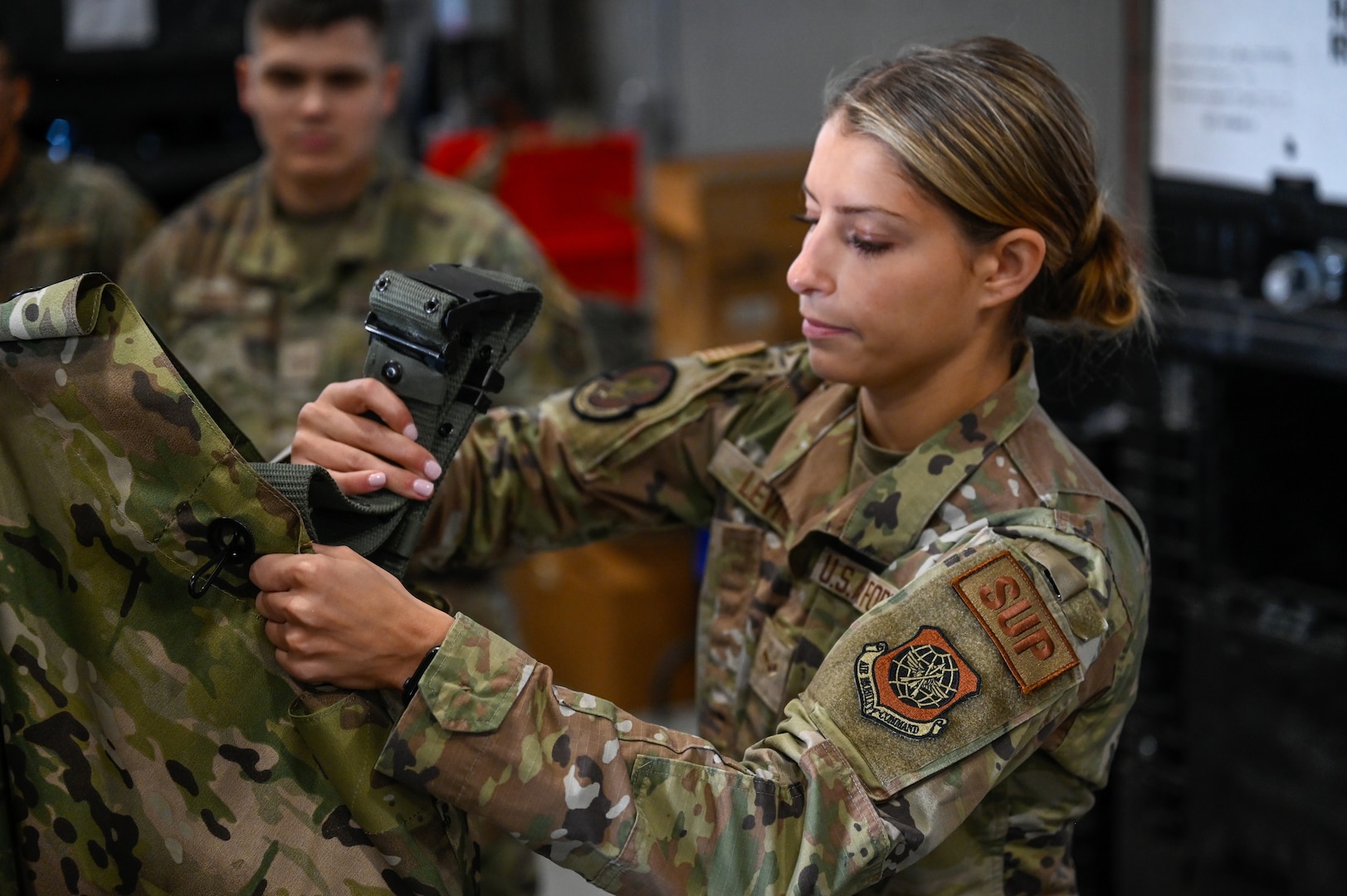 Airman 1st Class Ashlyn Levine, a supply specialist with the 157th Logistics Readiness Squadron, adds a canteen belt to an Airman's mobility bag, Sept. 7, 2024, at Pease Air Force Base, New Hampshire. The 157th Air Refueling Wing is set to deploy multiple KC-46 aircraft and more than 180 Airmen to Southeast Asia later this fall in what will be the first operational deployment of the Air Force’s next-generation tanker.