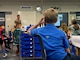 A group of students listen to a man in uniform provide a lecture.