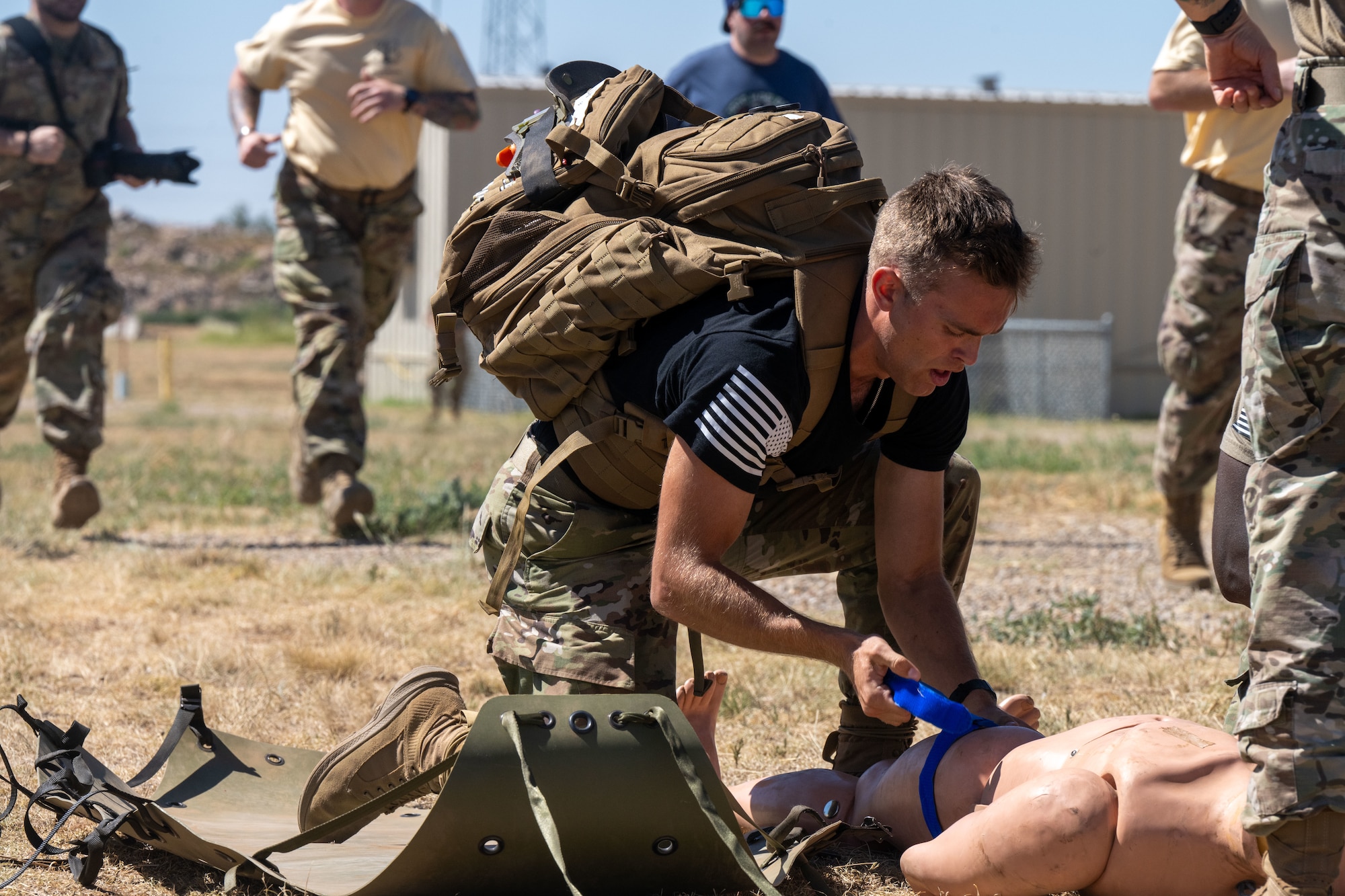 Airman 1st Class Adam Moster, 22nd Operational Medical Readiness Squadron bioenvironmental engineering technician, places a tourniquet on a mannequin during the annual Medic Rodeo Commando Challenge at Cannon Air Force Base, New Mexico, Aug. 15, 2024. The challenge required teams to run a quarter mile, place four tourniquets on a mannequin, sprint 100 yards with the mannequin and two 45-pound weights, complete 80 pushups and 80 burpees, place a junctional on the mannequin, and sprint back 100 yards to cross the finish line. (U.S. Air Force photo by Senior Airman Felicia Przydzial)