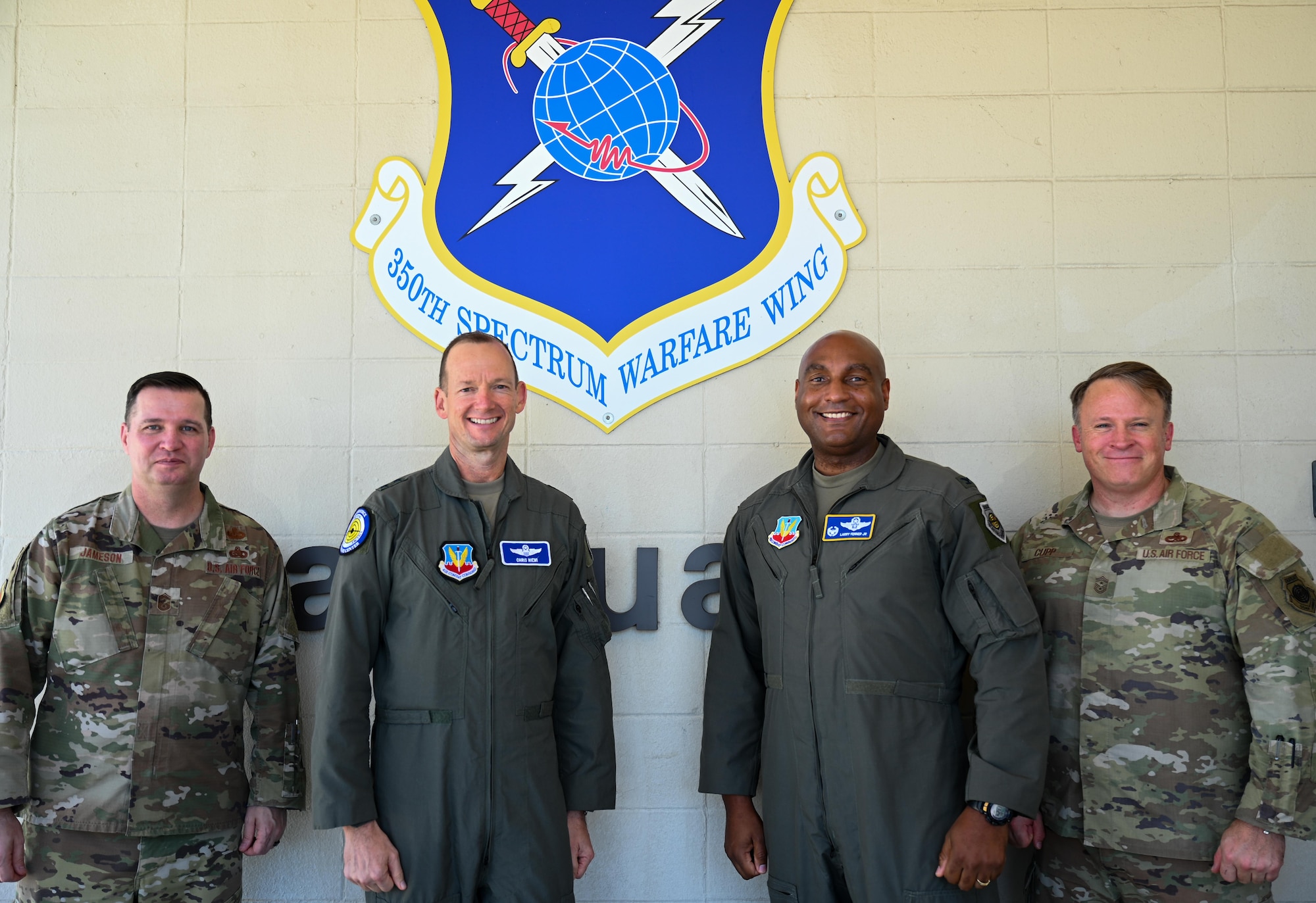 U.S. Air Force Chief Master Sgt. Gene Jameson III, U.S. Air Force Warfare Center command chief, far left, U.S. Air Force Maj. Gen. Christopher Niemi, commander of the USAFWC, left, U.S. Air Force Col. Larry Fenner Jr., 350th Spectrum Warfare Wing commander, right, and Chief Master Sgt. Will Cupp, 350th SWW command Chief, far right, pose for a photo during a visit to Eglin Air Force Base, Florida, Aug. 27, 2024. Niemi visited three wings across Eglin AFB and Hurlburt Field, including the 350th SWW, 53d Wing and 505th Command and Control Wing. (U.S. Air Force photo by Capt. Benjamin Aronson)