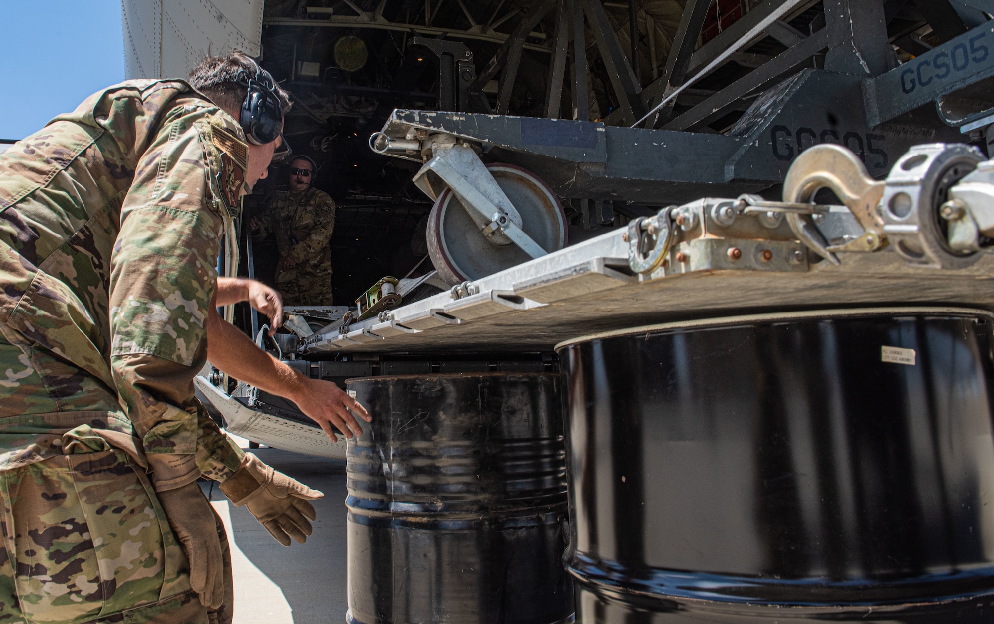 Airmen assigned to the 621st Contingency Response Squadron place barrels under a moving pallet for a combat offload operation during exercise Agile Flag 24-3 at Mojave, California, Aug. 8, 2024. During the operation Contingency Response Elements used simplified techniques to quickly and effectively offload resources and supplies. The 23rd Wing achieved certification within the Air Force Force Generation Model through AGILE FLAG 24-3. This exercise gave the most realistic representation of near-peer conflict to prepare the Wing to meet strategic objectives in any theater for future deployments while preparing today’s leaders for the rapid operational decisions and mission-type orders required to win against peer adversaries. (U.S. Air Force photo by Airman 1st Class Sir Wyrick)