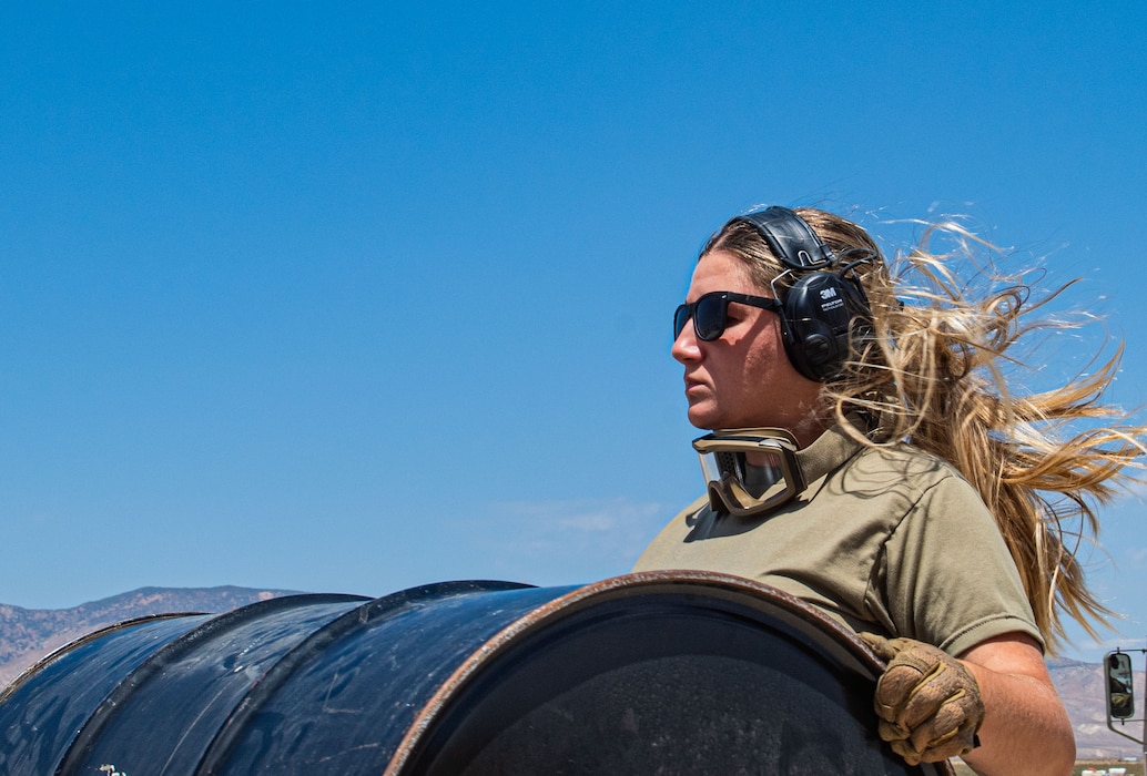 U.S. Air Force Staff Sgt. Bailee Jensen, 621st Contingency Response Squadron Personnel Support for Contingency Operations team member, carries a barrel drum for a combat offload operation during exercise Agile Flag 24-3 at Mojave, California, Aug. 8, 2024. The combat offload was performed to demonstrate the capabilities of the CRS and highlight the simple equipment that can be used in the austere environment. AGF 24-3 is an Air Combat Command certification exercise that tested the 23rd Wing’s ability to generate combat airpower while continuing to move, maneuver and sustain wing and subordinate force elements in a dynamic and contested environment. (U.S. Air Force photo by Airman 1st Class Sir Wyrick)