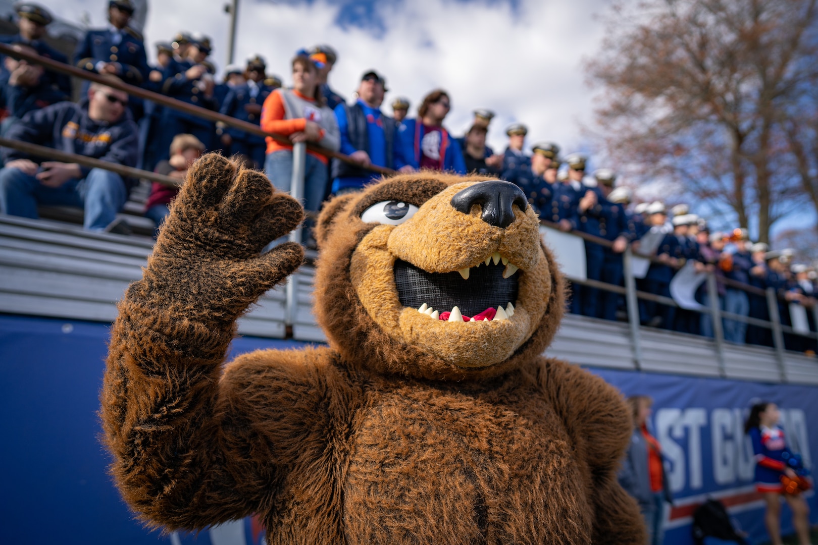 Objee waving to the camera during a football game.