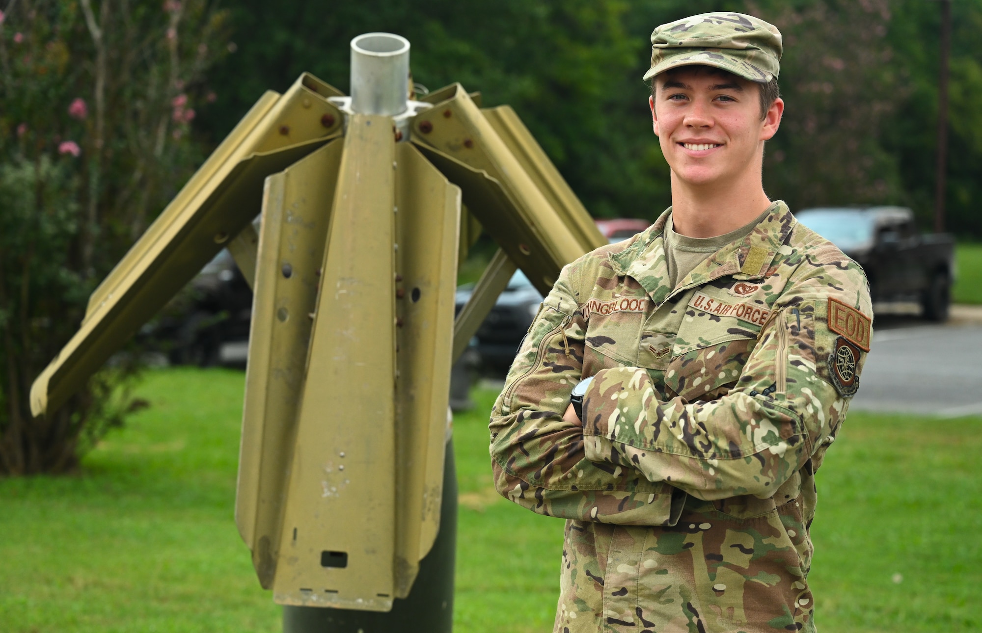 A man in uniform stands outside a building during the day.