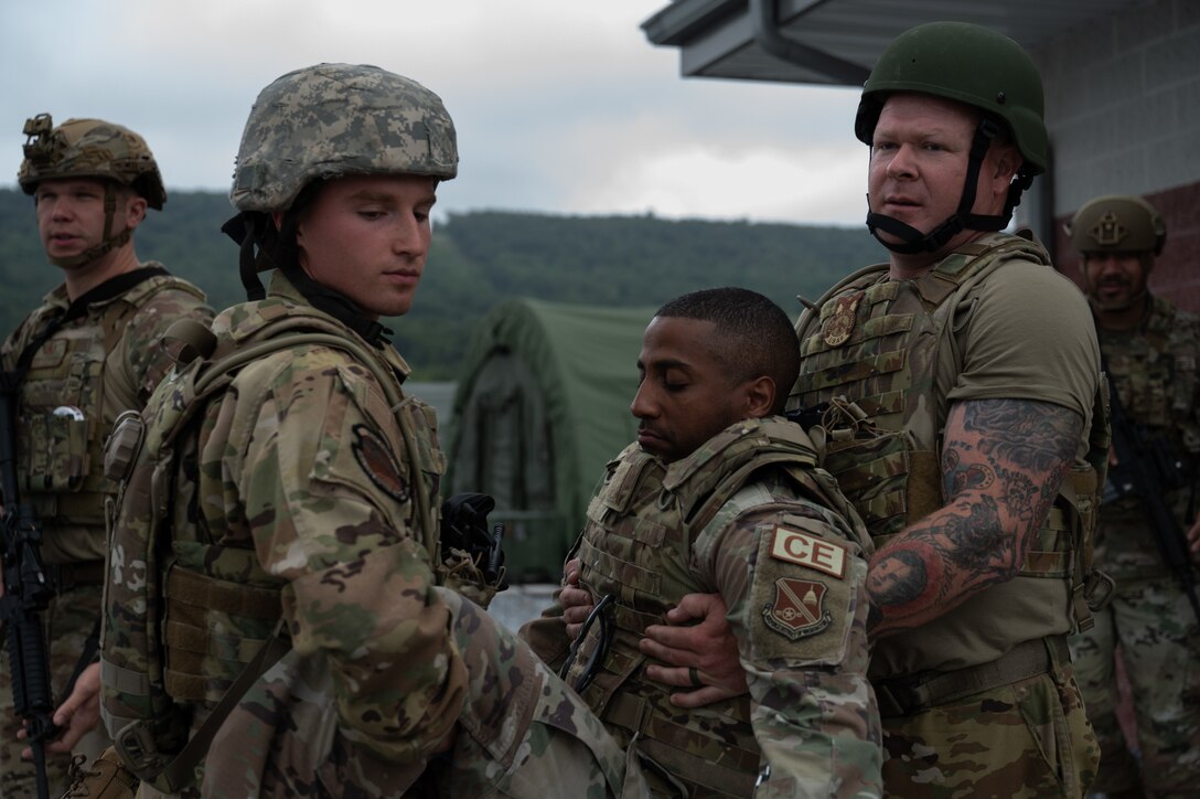 Airmen carrying another Airman