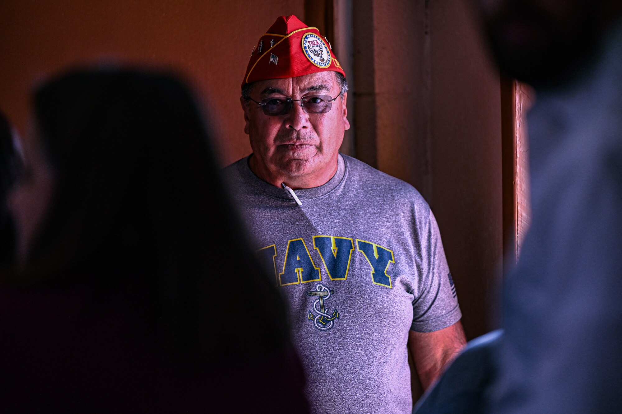 navy retiree stands in dark corner