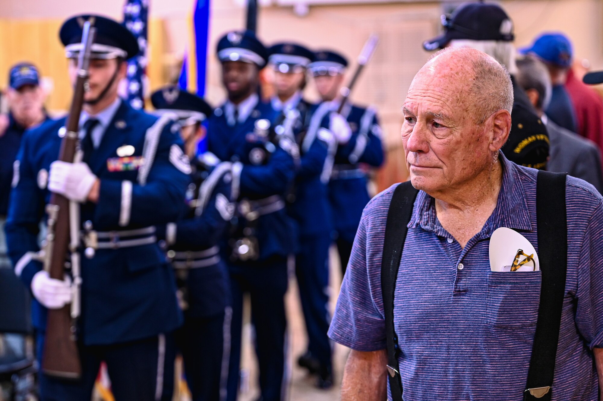 man stands as u.s. air force color guard passes