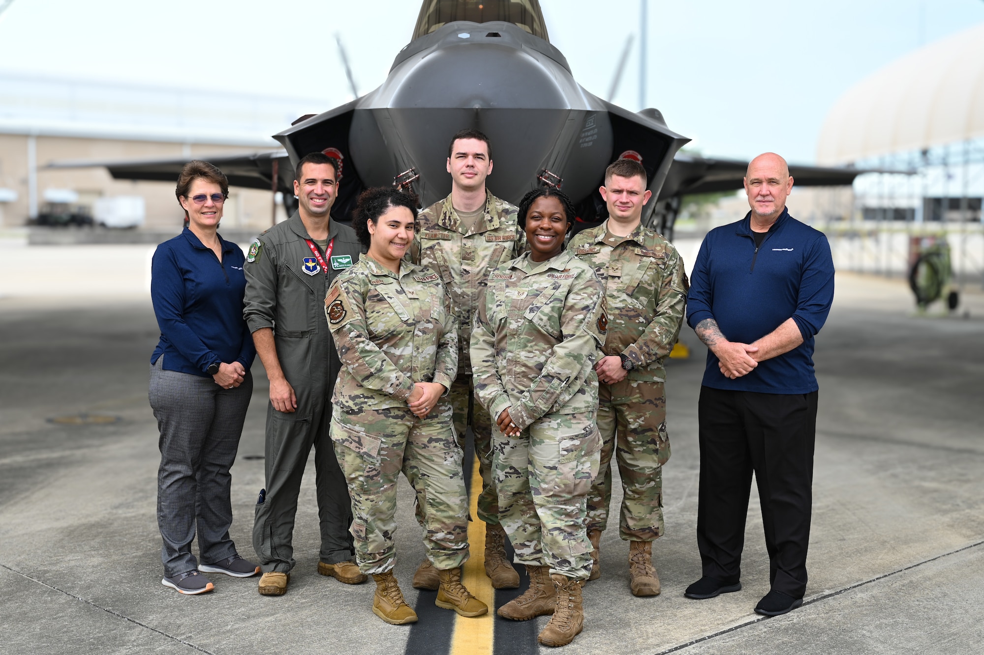 A group photo of Airmen and civilians in front of F-35.
