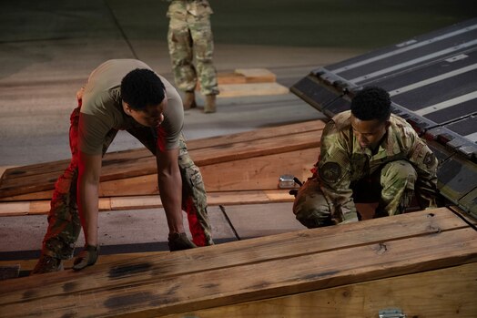  U.S. Air Force Airmen from the 30th Reconnaissance Squadron prepare to unload equipment from the back of a C-17 Globemaster III on the flightline at Joint Base Pearl Harbor Hickam, Hawaii, Aug. 27, 2024. The team arrived as part of a contingency operations exercise to test a piece of communications equipment known as the Mobile Constellation Control Station. (U.S. Air Force photo by Technical Sgt. Tarelle Walker)