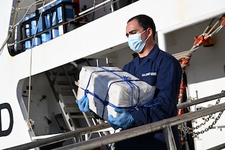 A crew member from Coast Guard Cutter Diligence carries a bale of cocaine during a drug offload at Port Everglades, Florida, Sept. 9, 2024. The offload was a result of three separate drug interdictions by Coast Guard and international partner crews in the Caribbean Sea worth an estimated $54 million dollars. (U.S. Coast Guard photo by Petty Officer 3rd Class Eric Rodriguez)