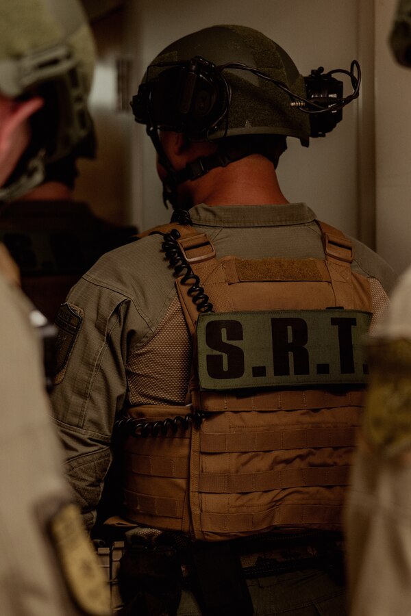 U.S. Marines with the Special Reaction Team, Provost Marshal’s Office (PMO), Headquarters and Support Battalion, clear a hallway during an emergency response drill on Marine Corps Base Camp Lejeune, North Carolina, Aug. 27, 2024. The drill was designed to test various aspects of the installation emergency managers, Fire and Emergency Services Division and PMO’s emergency security procedures to increase emergency response efforts and security capabilities. (U.S. Marine Corps photo by Cpl. Yasmine De La Rosa)