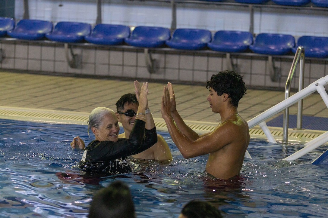 Jennifer Ayers, the Marine Corps Air Station Iwakuni aquatic director and a South Carolina native, high-fives a swim instructor during instructor training in the Marine Corps Community Services’ indoor pool on Sept. 4, 2024. Ayers and the MCAS Iwakuni aquatics team provide swim clinics and master classes, and train instructors with the goal to improve service members’ survival skills and increase their water confidence. (U.S. Marine Corps photo by Sgt. Phuchung Nguyen)