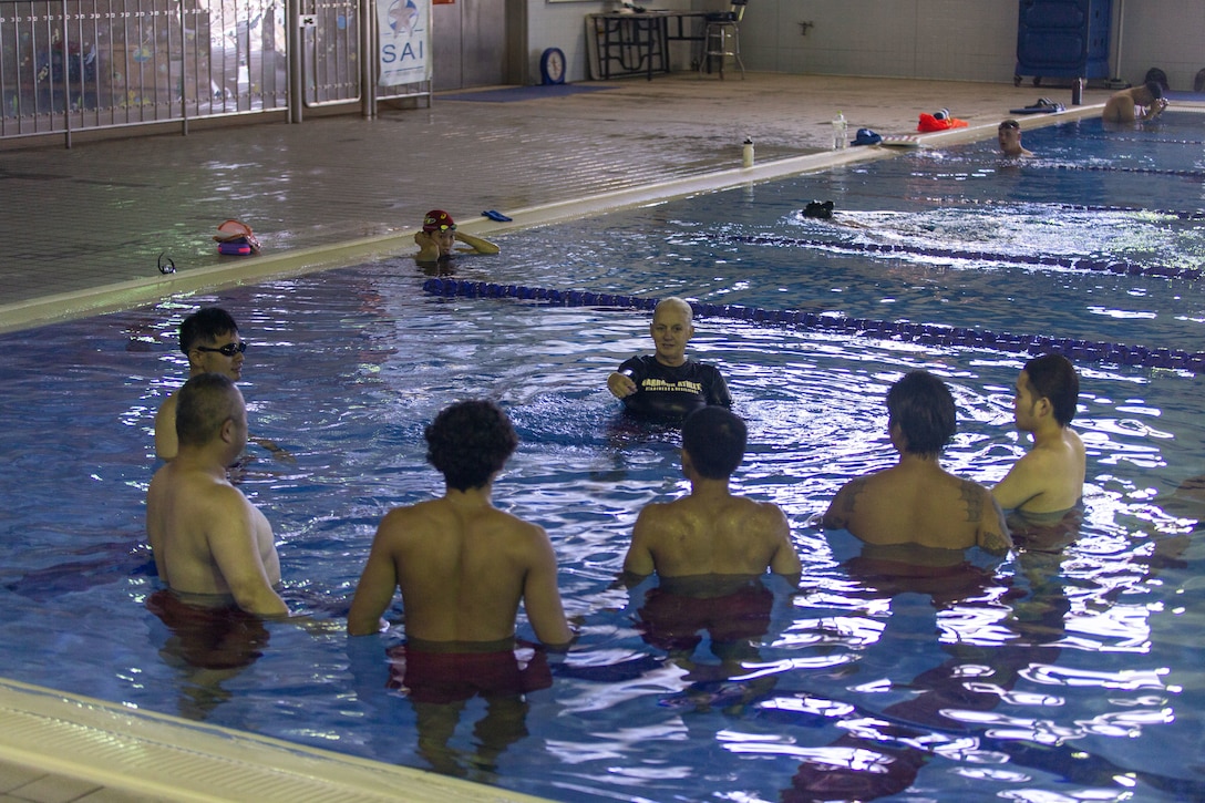 Jennifer Ayers, the Marine Corps Air Station Iwakuni aquatics director and a South Carolina native, briefs swim instructors during an instructor training in the Marine Corps Community Services’ indoor pool on Sept. 4, 2024. Ayers and the MCAS Iwakuni aquatics team provide swim clinics and master classes, and train instructors with the goal to improve service members’ survival skills and increase their water confidence. (U.S. Marine Corps photo by Sgt. Phuchung Nguyen)