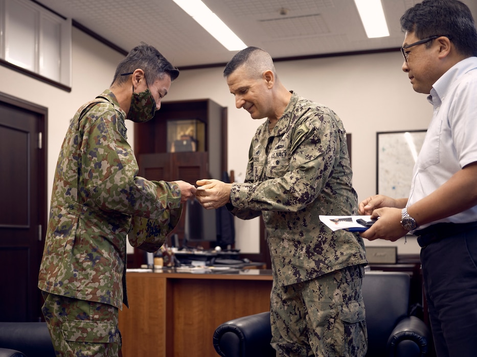 Japan Ground Self-Defense Force Col. Kouji Niita, the 31st Infantry Regiment Commander, and U.S. Navy Capt. Les Sobol, Commander, Fleet Activities Yokosuka, exchange business cards as custom in Japanese meetings September 10, 2024 during an office call with the installation commander.