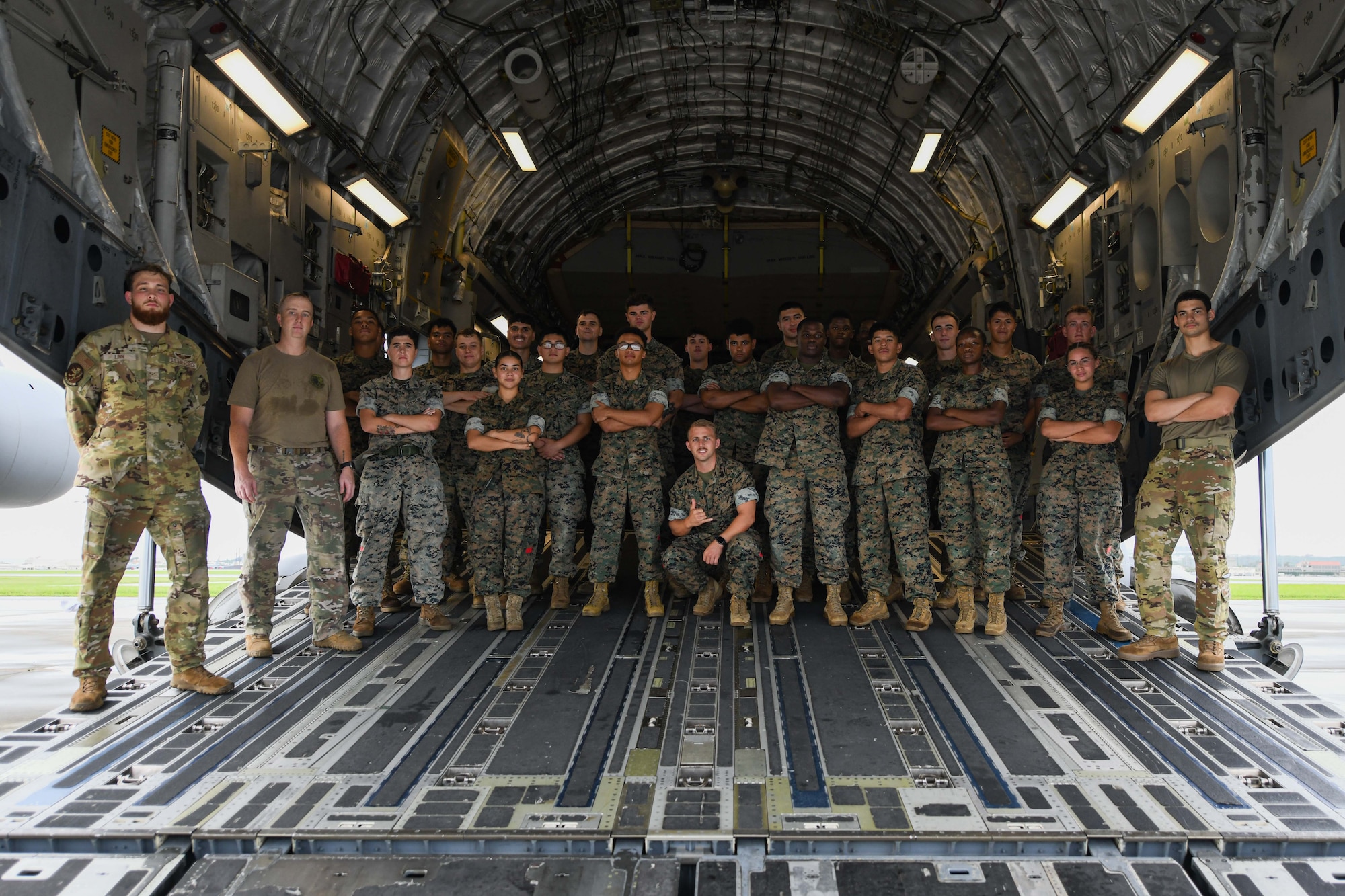 Marines and Airmen pose for a photo in the back of a C-17 Globemaster III.