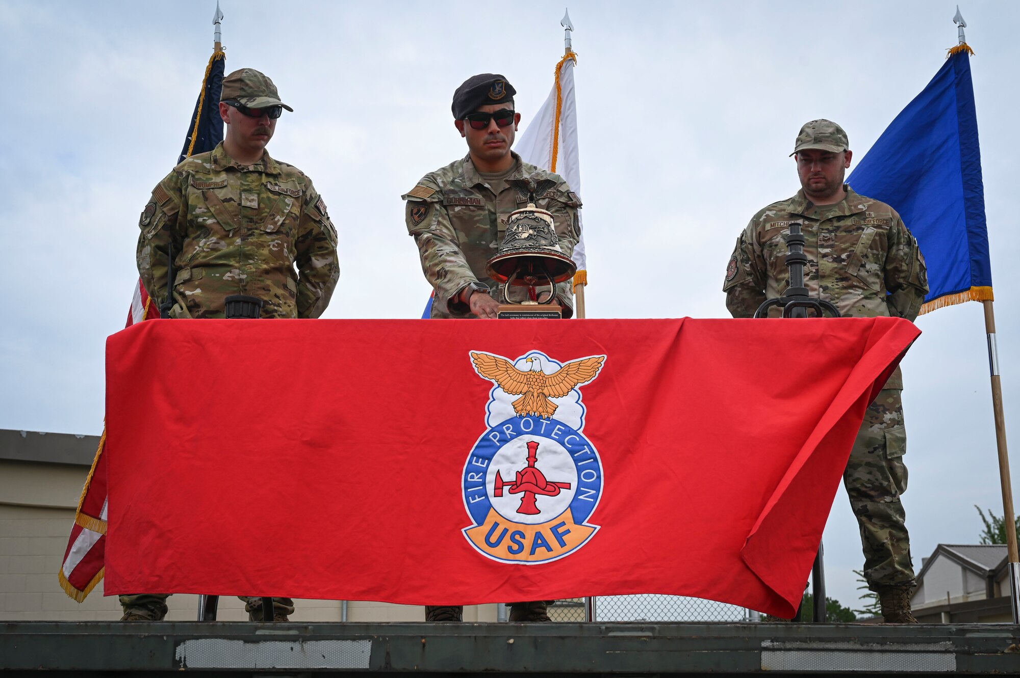 U.S. Air Force Staff Sgt. Ara Gureghian, center,  8th Security Forces Squadron military working dog handler, rings the ceremonial bell during the 9/11 Remembrance Ceremony.