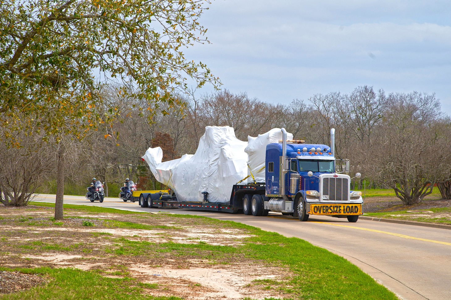 Marine One, BUNO 358, wrapped for transport by Clayton International, arrives in College Station, Texas, in February with police escort. A skilled team relocated the aircraft, which is on permanent loan from the National Museum of the Marine Corps