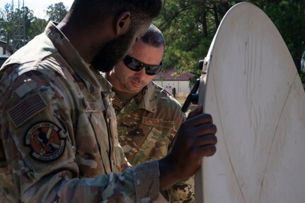 U.S. Air Force Tech. Sgt. Chavez Rollins, an RF transmission specialist and U.S. Air Force Tech. Sgt. Christopher Wightman, a cyber transportation specialist, both with the 232nd Combat Communications Squadron, connect an Airbus to a military satellite during a field exercise at a training facility in Central Alabama, Sept. 7, 2024.