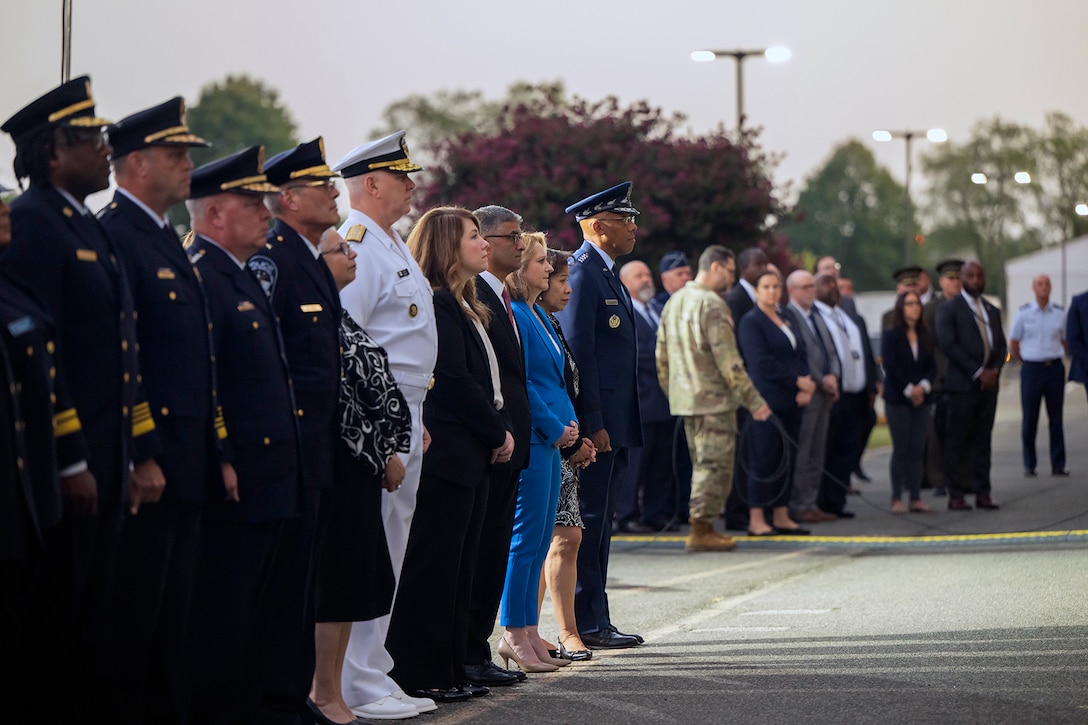Government officials stand at attention in a line.
