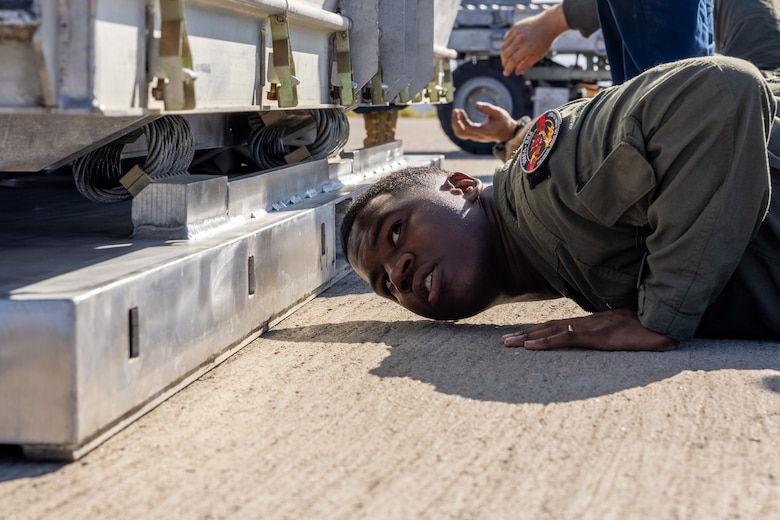 U.S. Marine Corps Cpl. Savion Calloway, an aviation ordnance systems technician with Marine Aviation Logistics Squadron 11, Marine Aircraft Group 11, 3rd Marine Aircraft Wing, guides Marines unloading an AGM-158A joint air-to-surface standoff missile during the AGM-158A validation and verification at Marine Corps Air Station Miramar, California