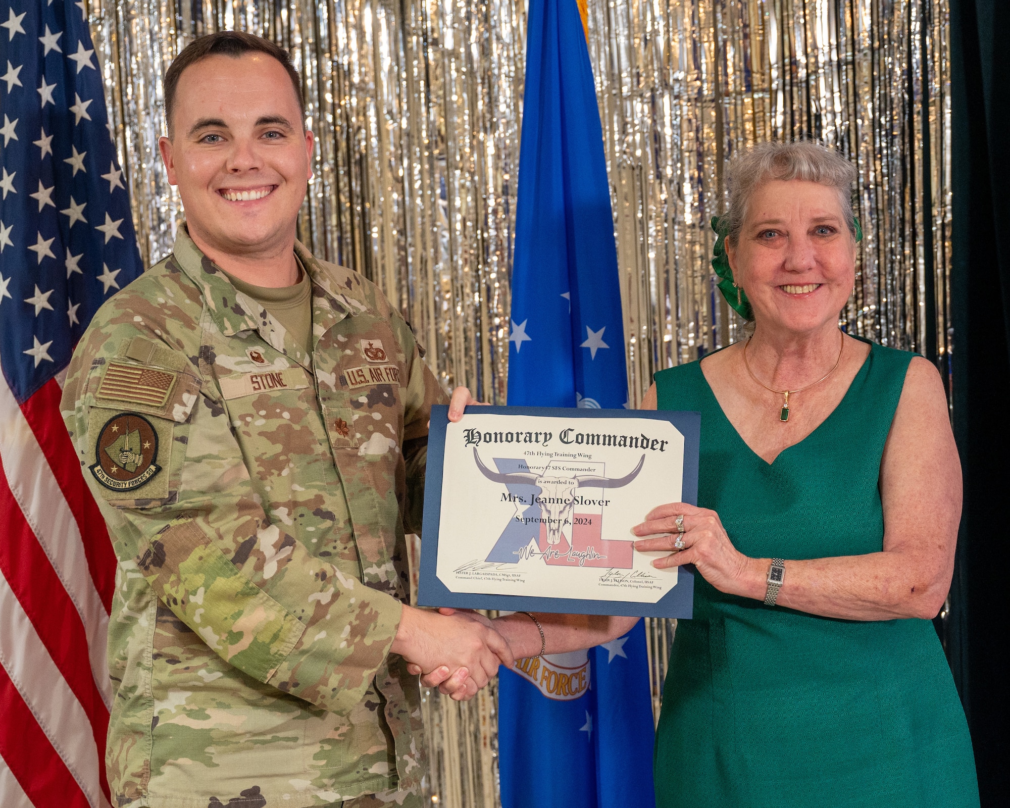An honorary commander accepts their certificate from their commander at the honorary commander induction ceremony at Laughlin Air Force Base, Texas, Sept. 6, 2024. The honorary commander program looks to bring local community leaders and base personnel closer together, fostering the close relationship between Del Rio and Laughlin. (U.S. Air Force photo by Staff Sgt. Nicholas Larsen)