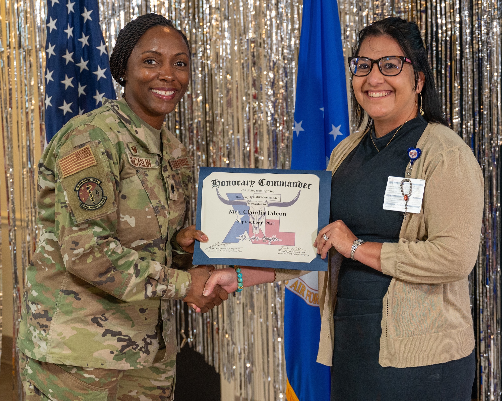 An honorary commander accepts their certificate from their commander at the honorary commander induction ceremony at Laughlin Air Force Base, Texas, Sept. 6, 2024. The honorary commander program looks to bring local community leaders and base personnel closer together, fostering the close relationship between Del Rio and Laughlin. (U.S. Air Force photo by Staff Sgt. Nicholas Larsen)