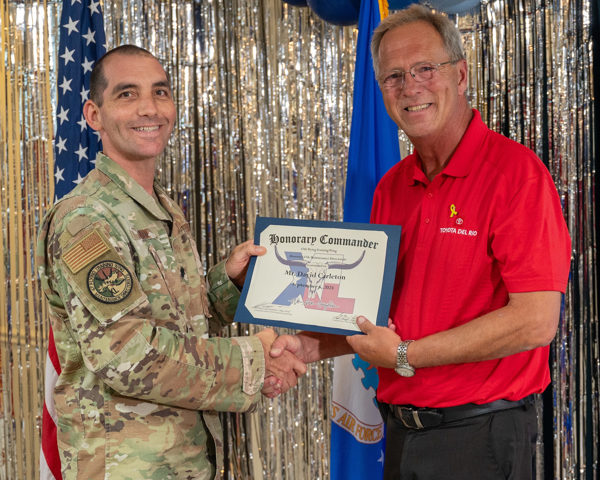 An honorary commander accepts their certificate from their commander at the honorary commander induction ceremony at Laughlin Air Force Base, Texas, Sept. 6, 2024. The honorary commander program looks to bring local community leaders and base personnel closer together, fostering the close relationship between Del Rio and Laughlin. (U.S. Air Force photo by Staff Sgt. Nicholas Larsen)