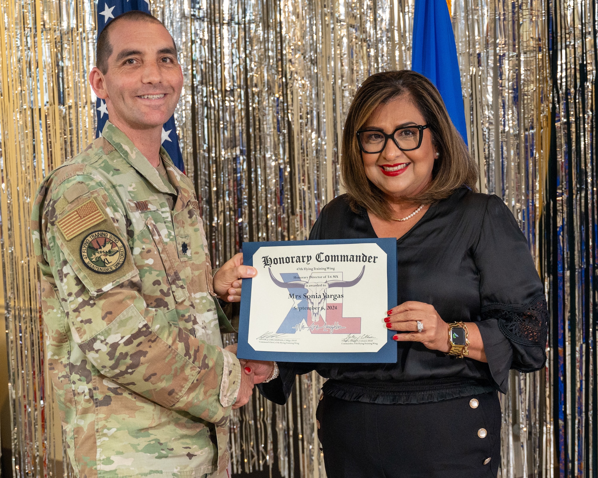 An honorary commander accepts their certificate from their commander at the honorary commander induction ceremony at Laughlin Air Force Base, Texas, Sept. 6, 2024. The honorary commander program looks to bring local community leaders and base personnel closer together, fostering the close relationship between Del Rio and Laughlin. (U.S. Air Force photo by Staff Sgt. Nicholas Larsen)