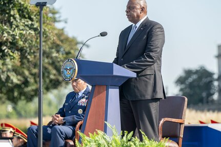 A person in business attire speaks at a lectern.