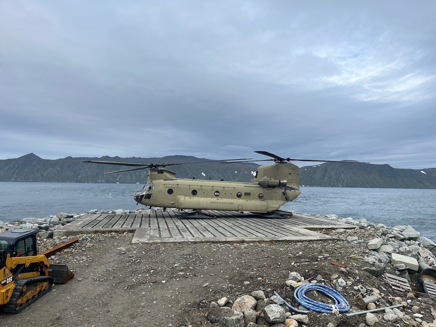 An Alaska Army National Guard CH-47 Chinook lands for the first time on Little Diomede, Alaska, with Big Diomede, Russia, visible in the background. The unit supported Operation Polar Dagger, a joint special operations mission across the Alaskan Arctic.