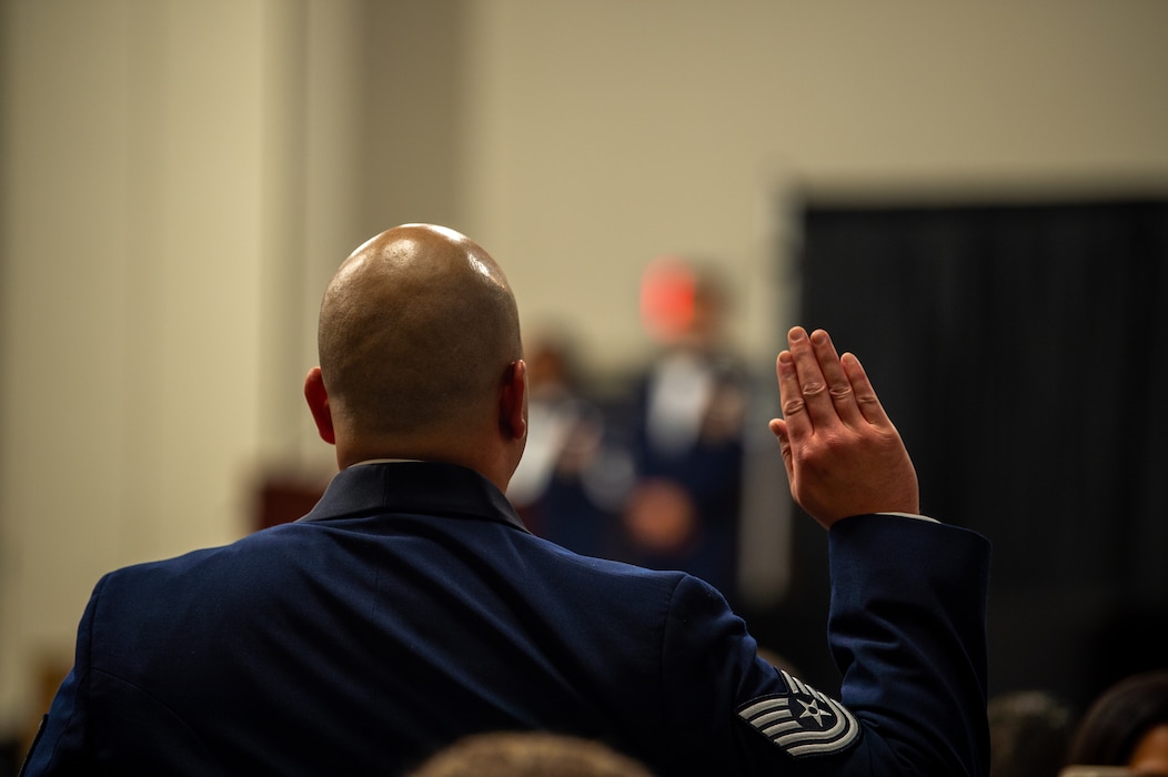 A U.S. Air Force Airman stands at attention during a senior noncommissioned officer (SNCO)induction ceremony at the Valdosta State University Ballroom, Valdosta, Georgia, Sept. 05, 2024. All SNCO inductees stood at attention and raised their right hand while the senior non-commissioned officer oath was read aloud. (U.S. Air Force photo by Airman 1st Class Iain Stanley)