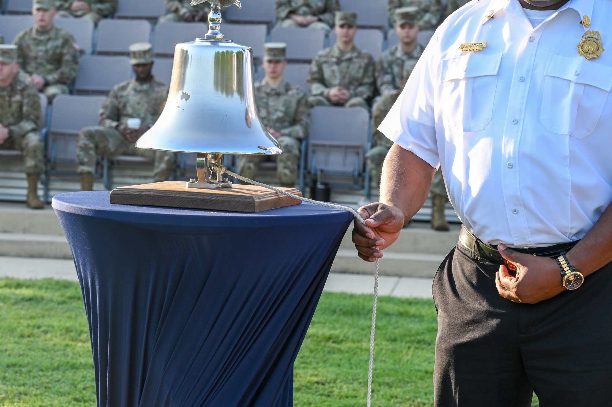 Darious Hawkins, fire chief of the Naval District Washington Fire and Emergency Services, tolls a bell in commemoration of the lives lost on 9/11 during the Remembrance Ceremony on Joint Base Anacostia-Bolling, Washington, D.C., Sept. 11, 2024. Tolling of the bell is reserved for moments of grief, signaling sorrow and demonstrating respect. (U.S. Air Force photo by Airman 1st Class Shanel Toussaint)
