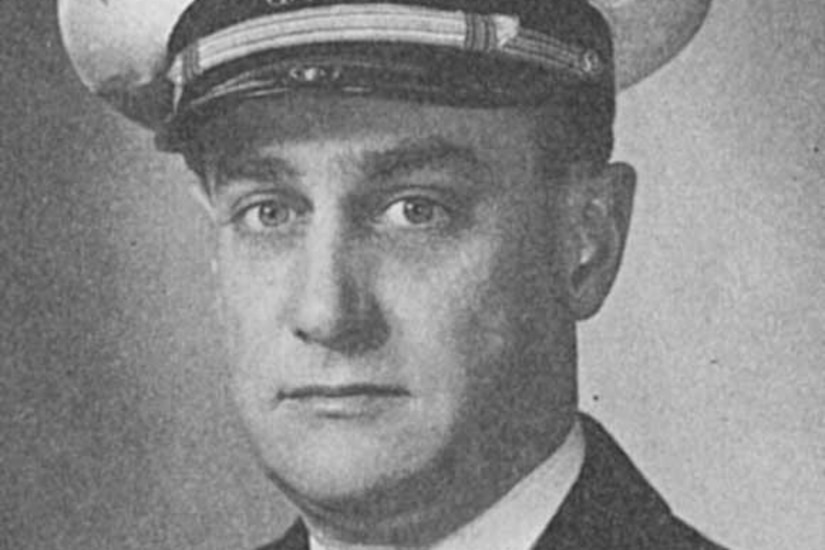 A man in uniform and cap poses for a photo.