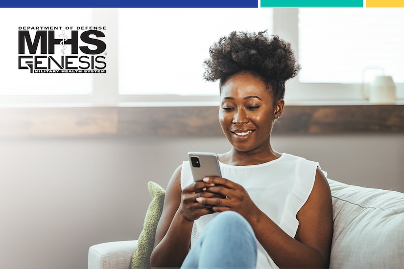 Woman sits on couch and smiles while looking down at smartphone.