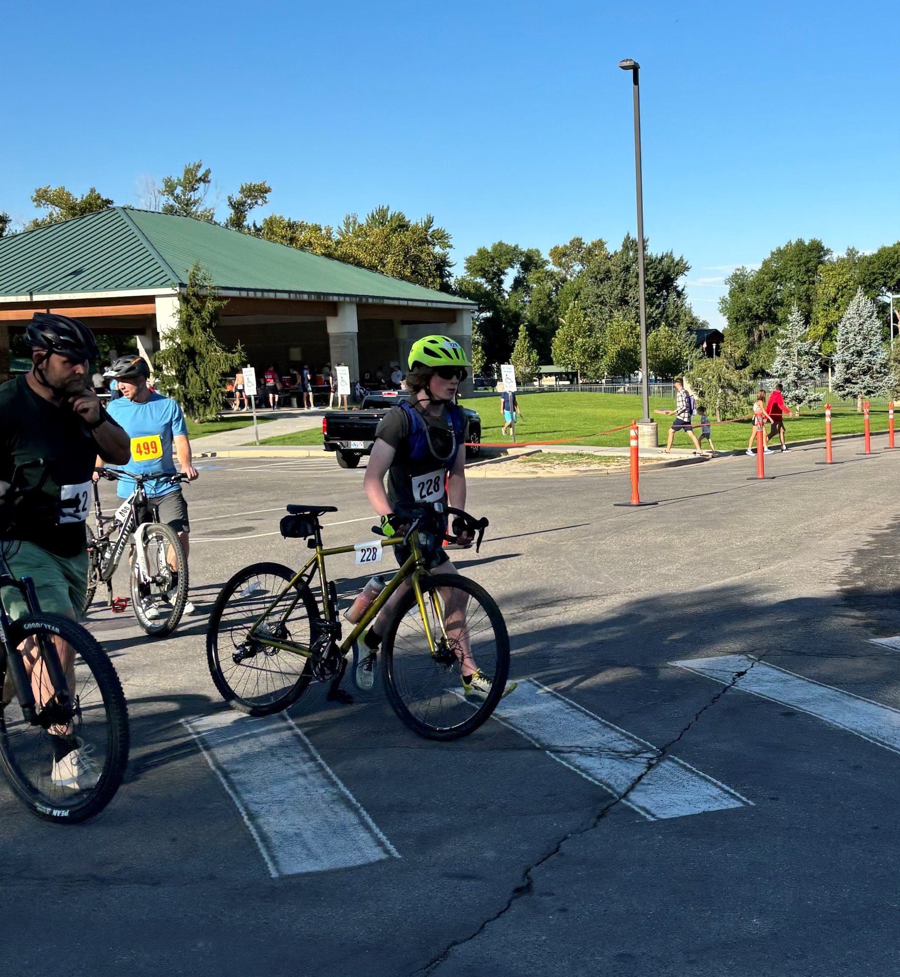 A boy walks a bicycle across a marked crosswalk