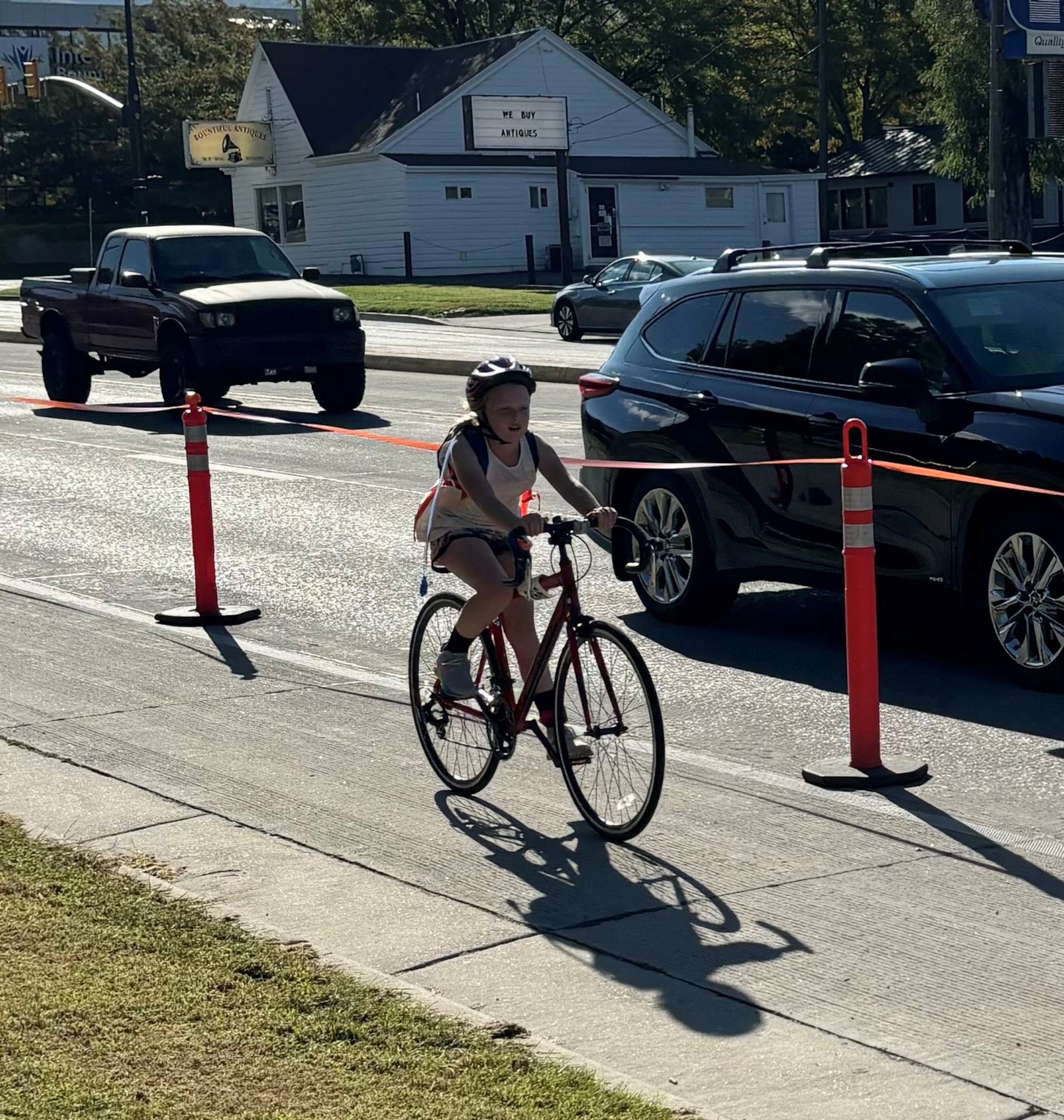 A girl rides a bike along a doad course