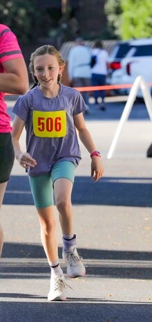 a girl runs along a road running course.