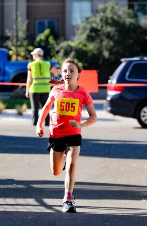 A young girl runs on a running course