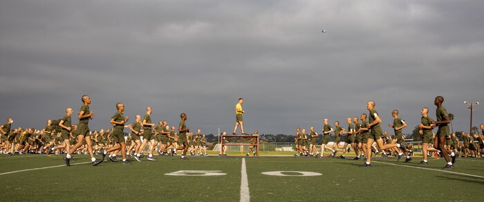 U.S. Marine Corps recruits with Hotel Company, 2nd Recruit Training Battalion, conduct dynamic warm-up exercises during a physical training session at Marine Corps Recruit Depot San Diego, California, Aug. 27, 2024. The recruits conducted a series of stations such as side shuffles, ammunition can lifts, planks, single-leg Romanian deadlifts, bicycle crunches, and 440-yard sprints during their physical training event strengthening themselves physically and mentally. (U.S. Marine Corps photo by Lance Cpl. Janell B. Alvarez)