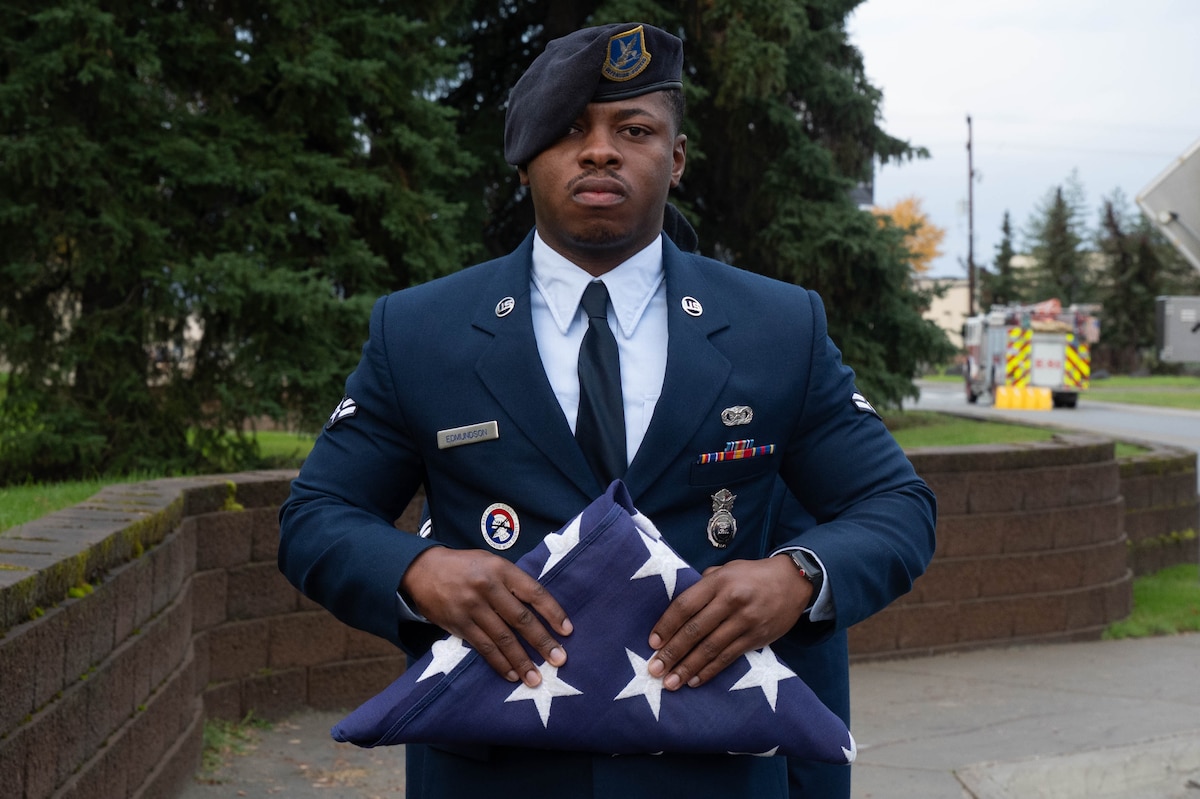 U.S. Air Force Airman 1st Class Tyler Edmundson, 354th Security Forces Squadron entry controller, holds a folded American flag during a 9/11 remembrance ceremony at Eielson Air Force Base, Alaska, Sept. 11, 2024.