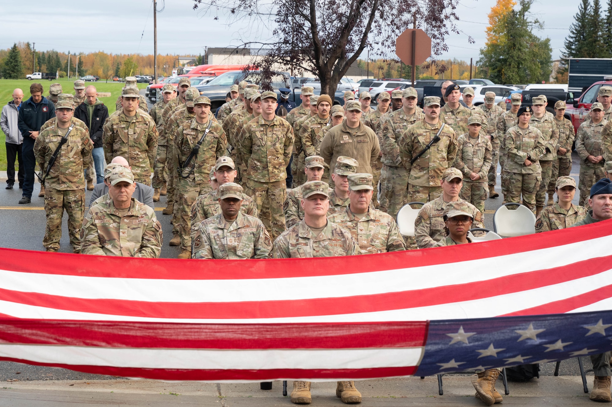 U.S. Air Force Airmen from the 354th Fighter Wing, 354th Civil Engineer Squadron and 354th Security Forces Squadron watch as an American flag is folded during a 9/11 remembrance ceremony at Eielson Air Force Base, Alaska, Sept. 11, 2024.