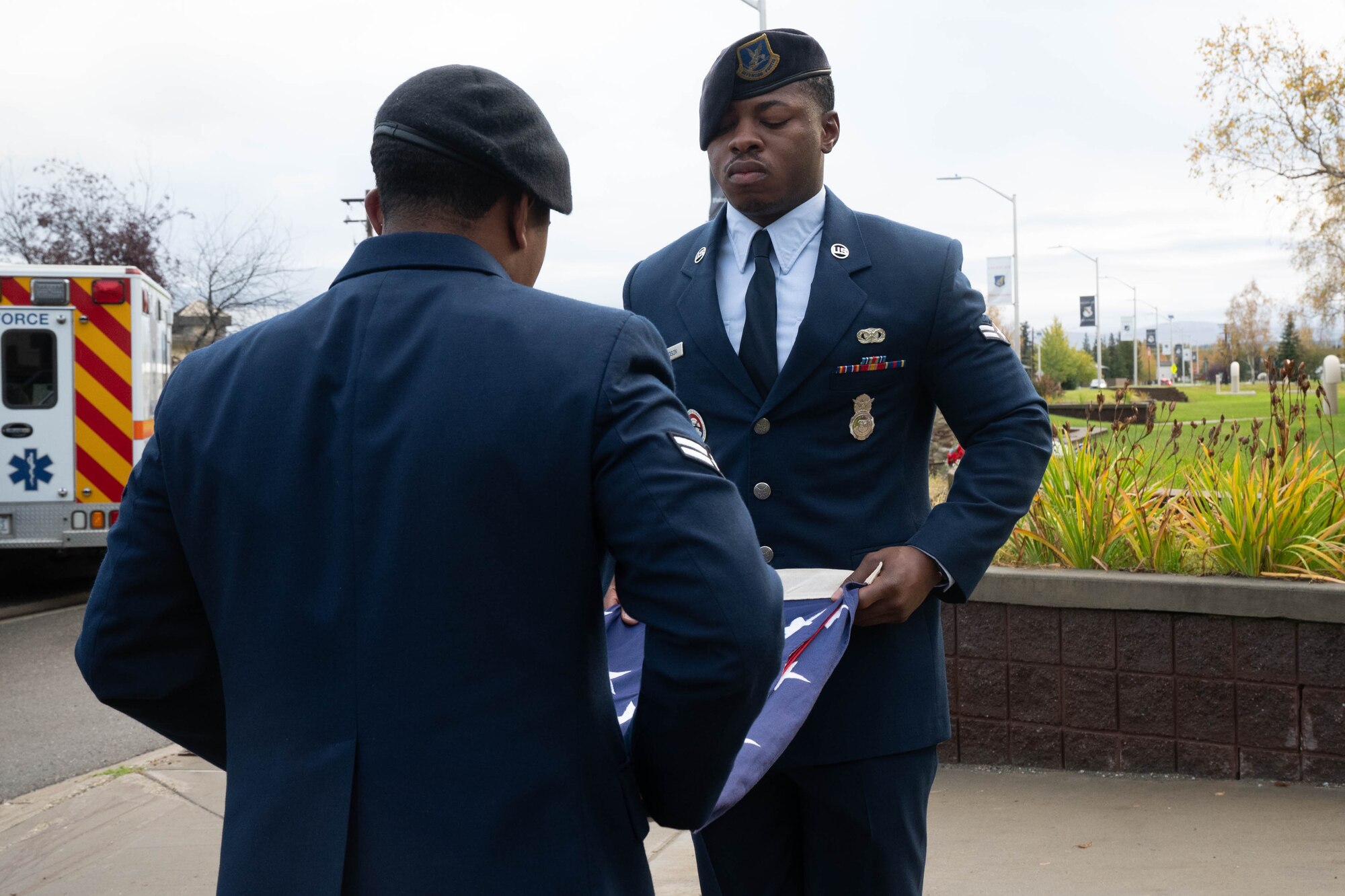 U.S. Air Force Airmen 1st Class Tyler Edmundson, center, and Patrick Garza, left, 354th Security Forces Squadron entry controllers, fold the American flag during a 9/11 remembrance ceremony at Eielson Air Force Base, Alaska, Sept. 11, 2024.