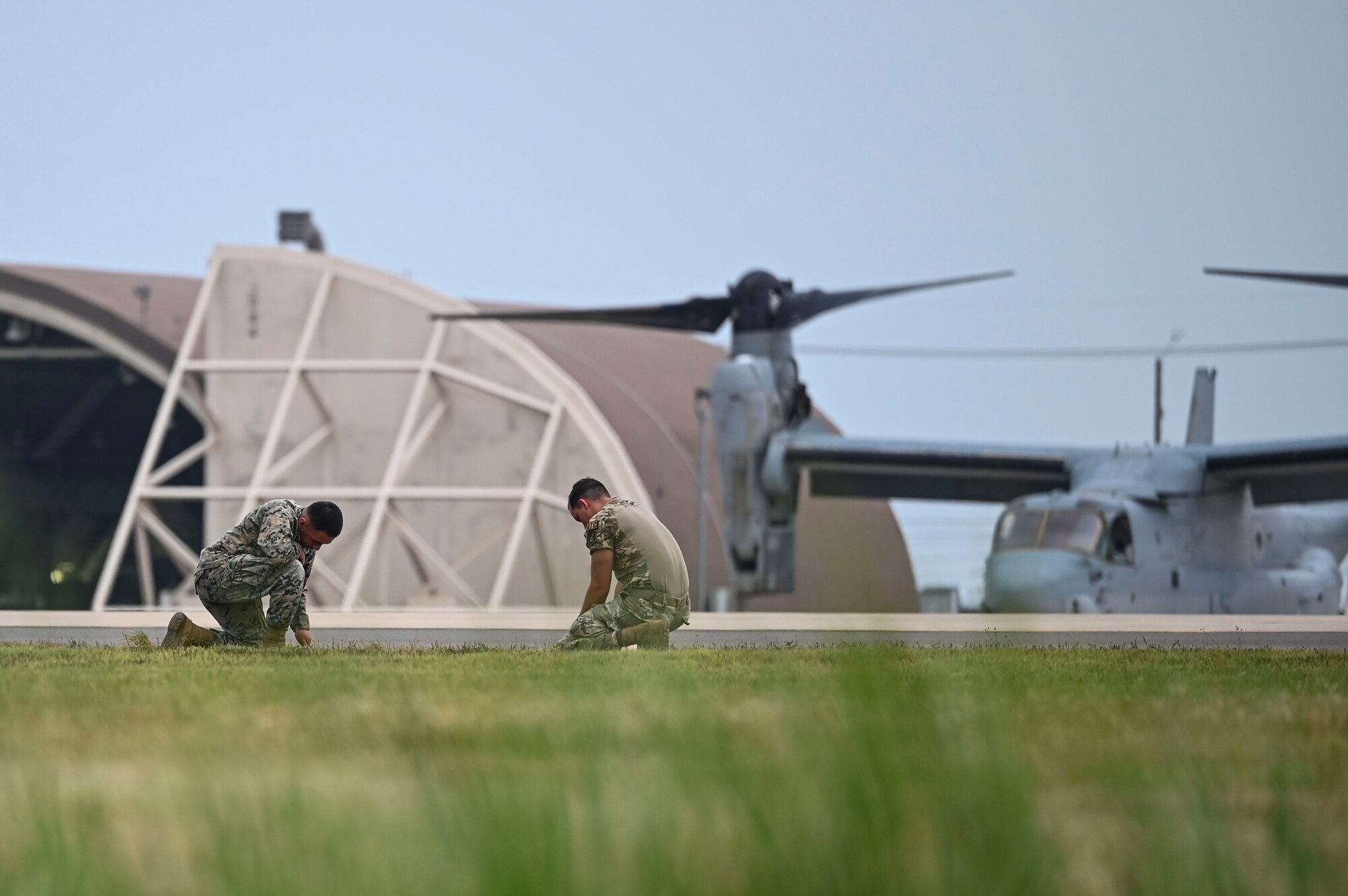 U.S. Marine Corps Sgt. Alex Ramirez, 8th OSS air traffic controller, and U.S. Air Force Tech Sgt. Tyler Twilley, left, 8th Operations Support Squadron radar approach control, set up a landing zone during helicopter landing zone operations at Kunsan Air Base, Republic of Korea