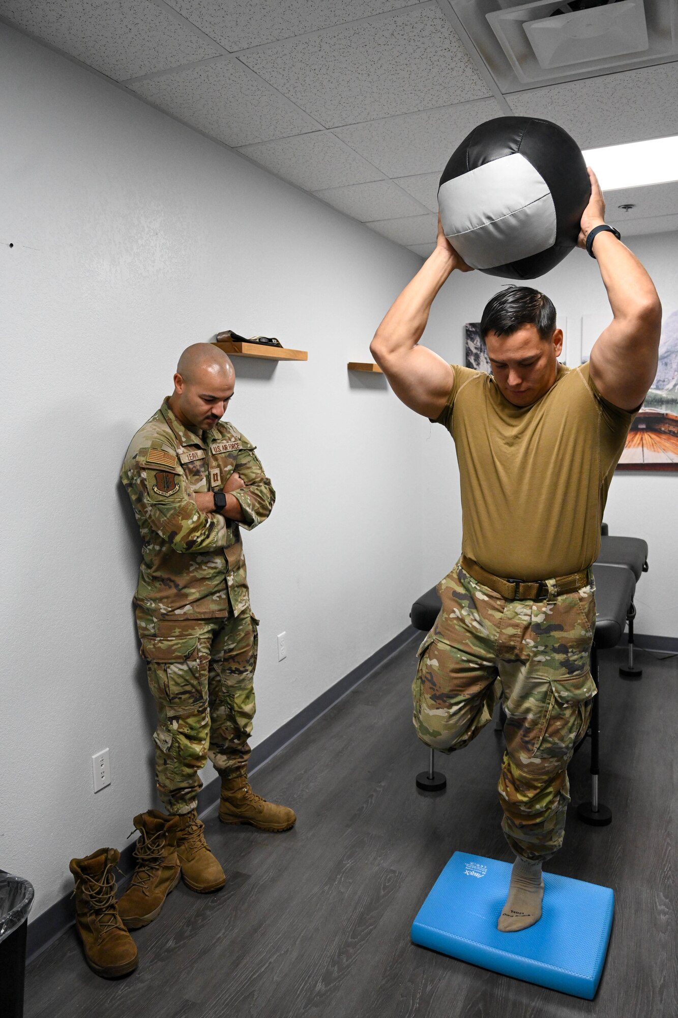 U.S. Air Force Staff Sgt. Brandon Gonzales, 97th Security Forces Squadron noncommissioned officer in charge of electric security systems, prepares to throw a medicine ball during a physical therapy session with Capt. Chase Leavy, 97th Operation Support Team physical therapist, at Altus Air Force Base, Oklahoma, Aug. 14, 2024. Medicine balls are used for strength training and rehabilitation. (U.S. Air Force photo by Senior Airman Miyah Gray)