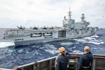Cmdr. Michael McInerney, commanding officer, Arleigh Burke-class guided-missile destroyer USS Russell (DDG 59), right, and Cmdr. Kailey Snyder, executive officer, salute the flagship of the Italian Navy aircraft carrier ITS Cavour (CV 550) during a multilateral exercise between the Italian Navy, Royal Australian Air Force, and U.S. Navy in the South China Sea, Sept. 9, 2024.