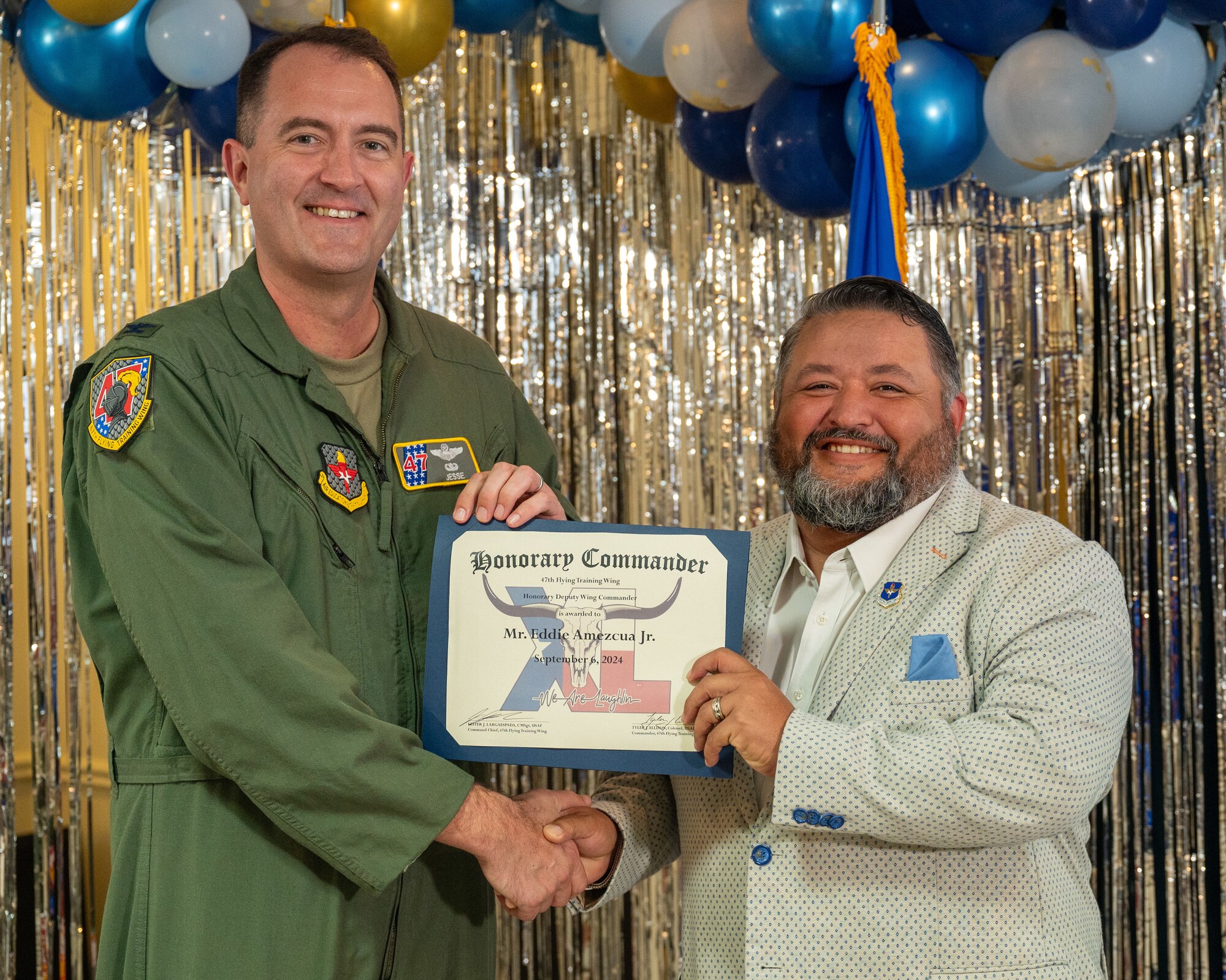An honorary commander accepts their certificate from their commander at the honorary commander induction ceremony at Laughlin Air Force Base, Texas, Sept. 6, 2024. The honorary commander program looks to bring local community leaders and base personnel closer together, fostering the close relationship between Del Rio and Laughlin. (U.S. Air Force photo by Staff Sgt. Nicholas Larsen)